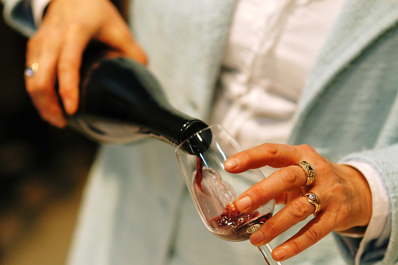 Rich red wine being carefully poured into a crystal wine glass