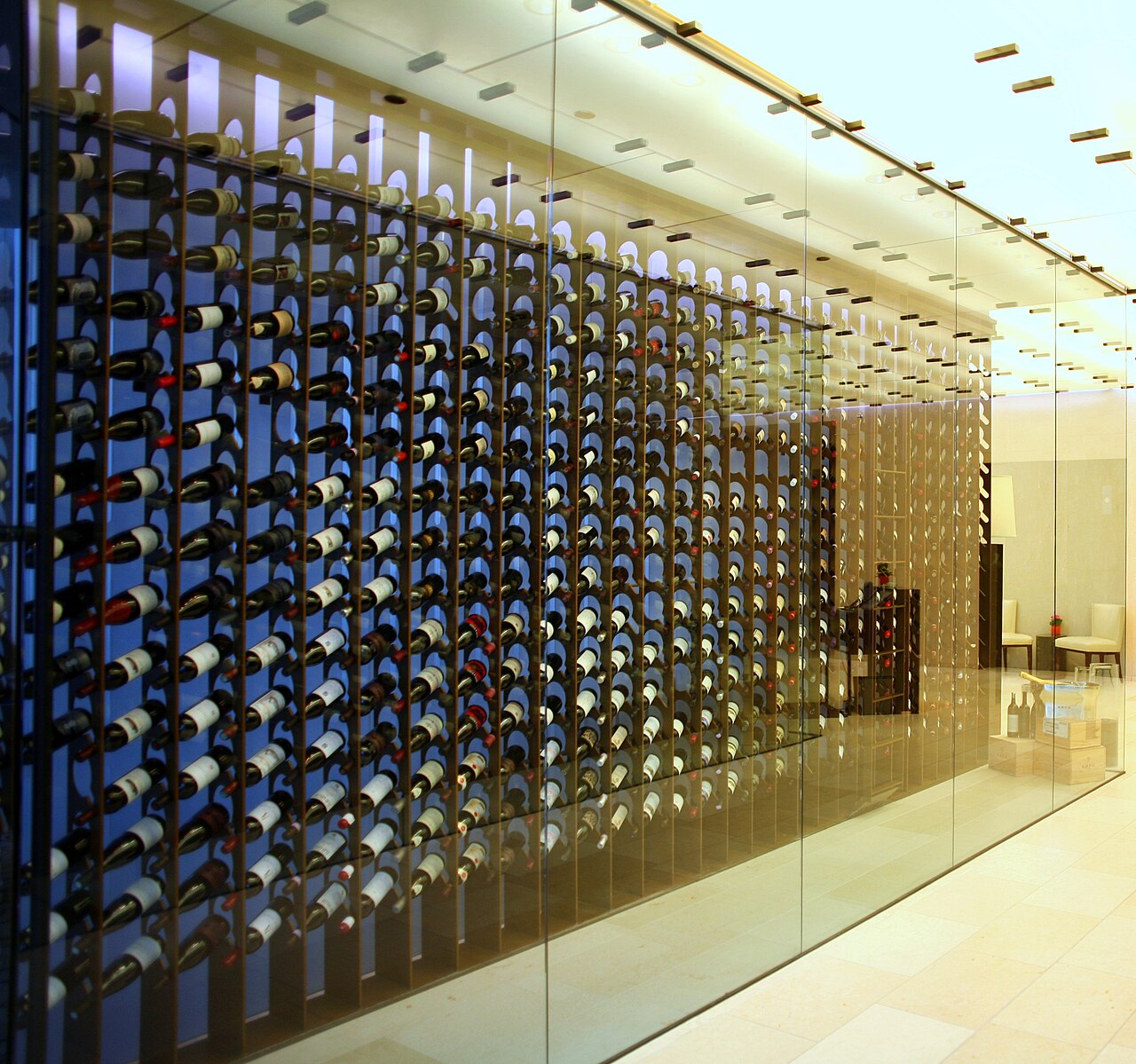 Interior architectural view of wine bottle racks behind glass display